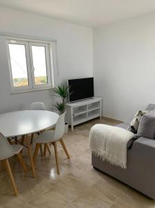 uma sala de estar com uma mesa e um sofá em Summer Reference em Tavira