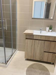 een badkamer met een wastafel en een douche bij Summer Reference in Tavira