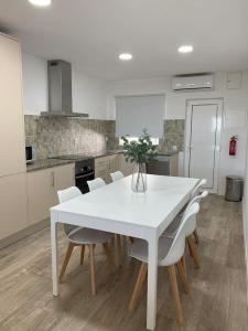a kitchen with a white table and white chairs at Summer Reference in Tavira