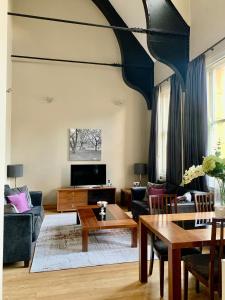 a living room with a couch and a table at Quebecs Luxury Apartments in Leeds