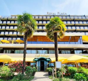 a hotel with palm trees in front of a building at Villa Toscane in Montreux