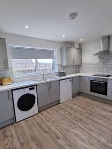 a kitchen with a sink and a dishwasher at Copper Cottage in Rothbury