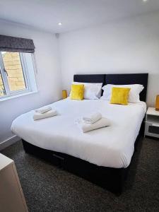 um quarto com uma cama grande e almofadas amarelas em Copper Cottage em Rothbury