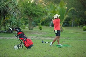 una mujer está jugando al golf con un cochecito en Nosy Saba Private Island & Spa, en Nosy Saba