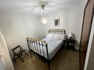 1 dormitorio con cama, mesa y lámpara de araña en HABITACIÓN con baño uso privado CENTRO Málaga., en Málaga
