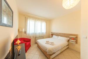 1 dormitorio con 1 cama y 1 silla roja en HouSmart San Lazzaro Salvo D'Acquisto 16, en San Lazzaro di Savena