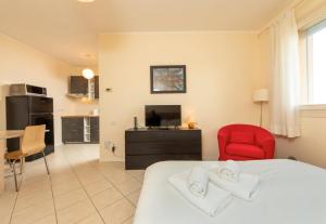1 dormitorio con 1 cama y 1 silla roja en HouSmart San Lazzaro Salvo D'Acquisto 16, en San Lazzaro di Savena