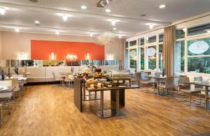 a restaurant with tables and chairs in a room at Flussbett Hotel in Gütersloh