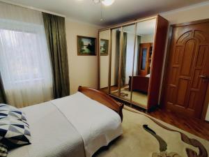 1 dormitorio con cama y espejo grande en Kiki's Villa, en Chişinău