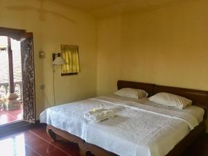 a bedroom with a bed with two towels on it at Puri Mandala Kaleran in Ubud