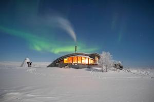 ein großes Glasgebäude im Schnee auf einem Feld in der Unterkunft Hillagammi, the unique beauty in the Wilderness in Utsjoki