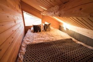 ein großes Holzbett in einem Holzzimmer in der Unterkunft Hillagammi, the unique beauty in the Wilderness in Utsjoki