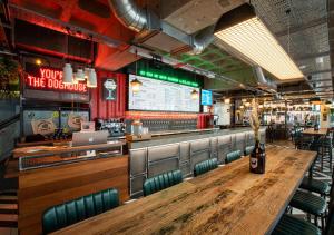 un restaurante con una larga mesa de madera y sillas en BrewDog DogHouse Manchester en Mánchester