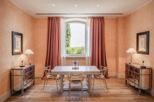 a dining room with a table and a window at L'Andana Tenuta La Badiola in Castiglione della Pescaia