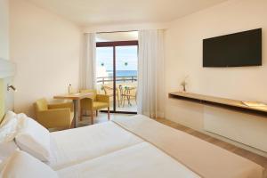 a hotel room with a bed and a table with chairs at Hotel Sabina Playa in Cala Millor