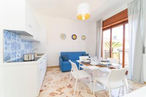 a kitchen and dining room with a white table and chairs at Mauri Dolce & Vita Luxury House and Apartment in the town center in Maiori