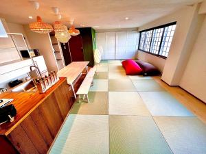 a large room with a kitchen with a large tile floor at Swiss Inn in Sapporo