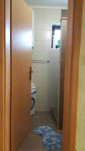 łazienka z toaletą i drzwiami z dywanem w obiekcie Guest house Una w mieście Bihać