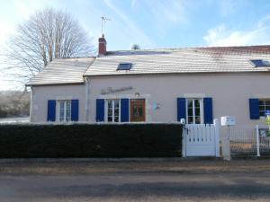 a white house with blue shutters and a fence at La Parisienne des Amognes in Montigny-aux-Amognes