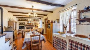 una cucina e una sala da pranzo con tavolo e sedie di Cortijo La Alberquilla Íllora by Ruralidays a Illora