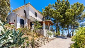una casa bianca su una collina con alberi di Cortijo La Alberquilla Íllora by Ruralidays a Illora