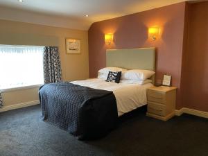 a bedroom with a large bed and a window at The Windmill Inn 