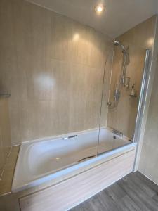a bath tub with a glass shower in a bathroom at The Windmill Inn 