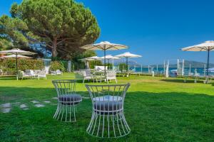 a group of chairs and tables with umbrellas at The Pelican Beach Resort & SPA - Adults Only in Olbia