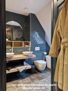 ein Badezimmer mit 2 Waschbecken und einem Spiegel in der Unterkunft Het Pauwtje in Zoutelande