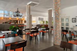 オルビアにあるザ ペリカン ビーチ リゾート＆スパ - アダルト オンリーのテーブルと椅子のあるレストラン、バー