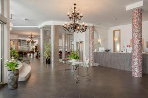 a living room with a chandelier and a lobby at The Pelican Beach Resort & SPA - Adults Only in Olbia