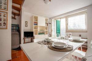 a white kitchen with a table with wine glasses on it at Casa Le Cellane in Castel del Piano