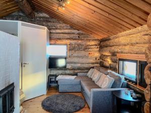 una sala de estar con sofá en una cabaña de madera en Tunturikelo - beautiful log cottage in the Fells, en Utsjoki