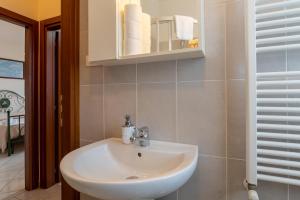 un bagno con un lavandino bianco e uno specchio di Papà Giuseppe La Terrazza a Cortona Altre 19 foto