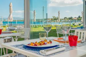 a table with a plate of food and wine glasses at The Pelican Beach Resort & SPA - Adults Only in Olbia