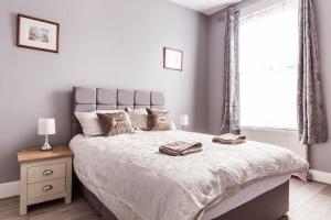 Un dormitorio con una cama grande y una ventana en 4 bedroom house, 2 Min Walk From Station, en Londres