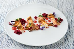 a white plate with food on a table at The Pelican Beach Resort & SPA - Adults Only in Olbia