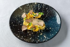 a black plate with a dessert on a table at The Pelican Beach Resort & SPA - Adults Only in Olbia