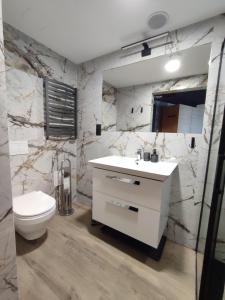 a bathroom with a white sink and a toilet at Apartament 413 Biała Perła in Stronie Śląskie