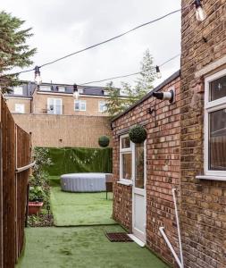 a backyard with a garden with a couch in it at 4 bedroom house, 2 Min Walk From Station in London