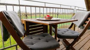 a table and two chairs on a wooden deck at Landhaus Charlotte - Storchennest in Wassersuppe