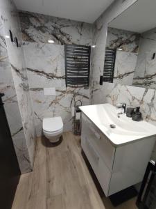 a bathroom with a white sink and a toilet at Apartament 413 Biała Perła in Stronie Śląskie