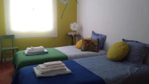 two beds in a room with towels on them at House pc in Porto da Cruz