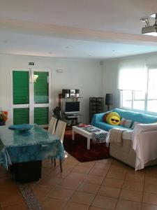 House pc في بورتو دا كروز: غرفة معيشة مع أريكة زرقاء وطاولة