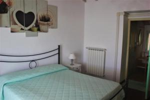 a bedroom with a bed with a green comforter at Fattoria Cristina - Bilo Verde in Castelnuovo Magra