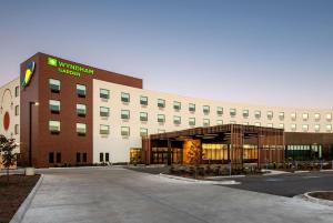 un edificio de oficinas con un edificio con un cartel en él en Wyndham Garden Winnipeg Airport en Winnipeg