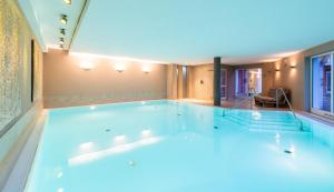 a large swimming pool in the middle of a room at Strandhafer Aparthotel in Warnemünde