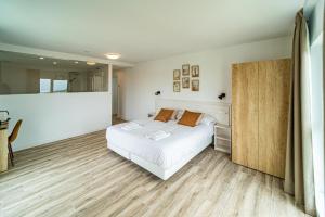 a bedroom with a white bed and wooden floors at Alima Surf & Hotel in Ajo +45 photos