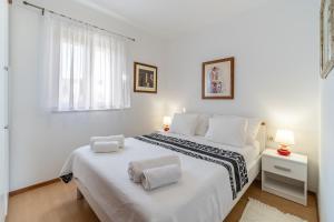 a white bedroom with two beds and a window at Apartman Vesna Uvala Makarac Milna in Milna