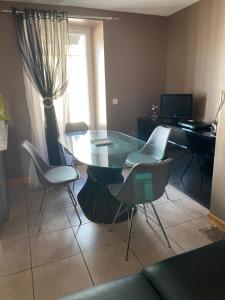 a dining room with a glass table and chairs at Appartement centre Granville in Granville